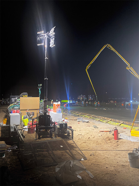 Diesel-powered portable LED light tower illuminating a construction site at night.